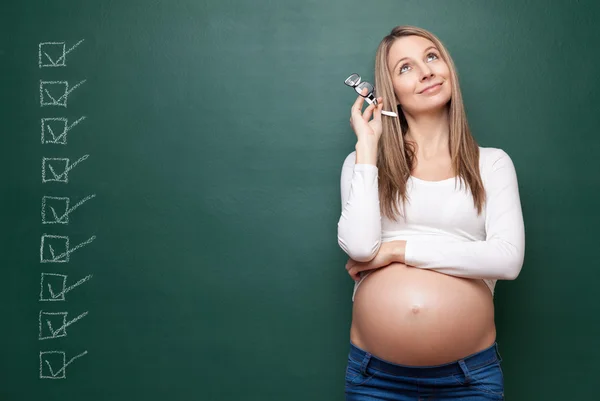 Mulher grávida e um quadro negro com copyspace — Fotografia de Stock