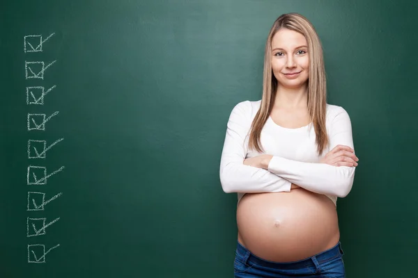 Mulher grávida e um quadro negro com copyspace — Fotografia de Stock