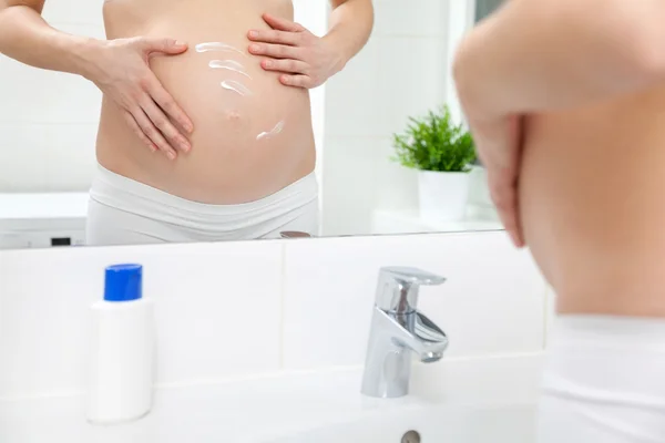 Schwangere im Badezimmerspiegel — Stockfoto