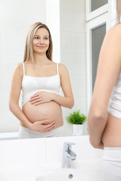 Femme enceinte dans le miroir de salle de bain — Photo