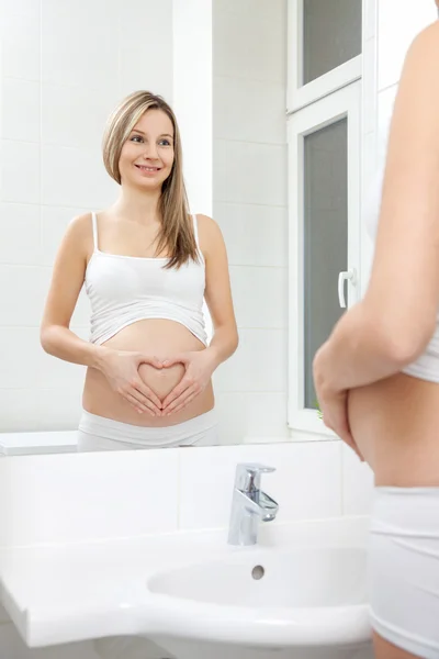 Femme enceinte dans le miroir de salle de bain — Photo