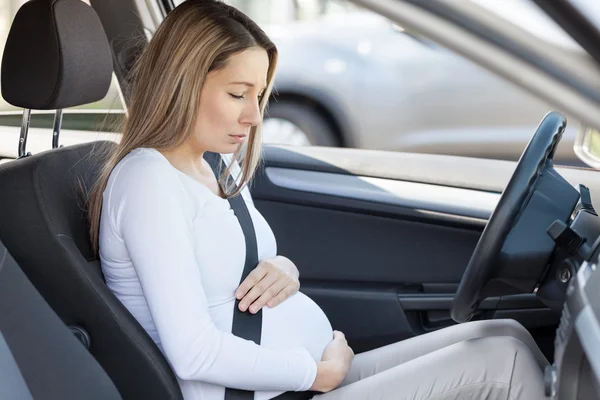 Těhotná žena za volantem s kontrakce — Stock fotografie