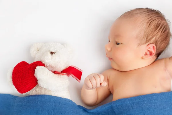 Niedliches Neugeborenes mit einem Teddybär unter einer Decke — Stockfoto