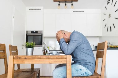 Salgın sırasında evinden çalışan mutsuz bir adam.