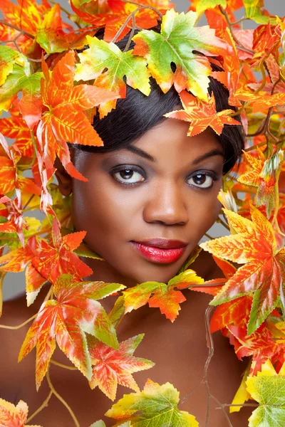 Belle jeune femme enveloppée dans des feuilles — Photo