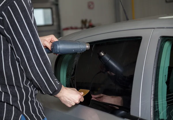 Kleurfolie aanbrengen op een autoraam — Stockfoto