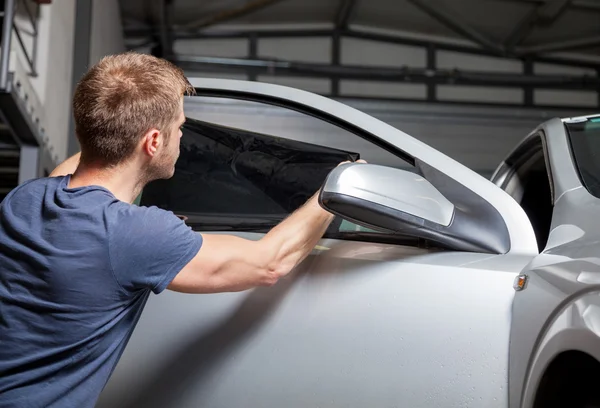 Applying tinting foil on a car window — Stock Photo, Image