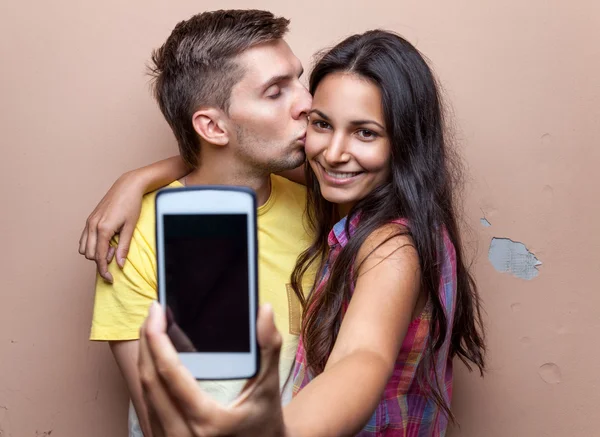 Jeune couple heureux prenant un selfie — Photo