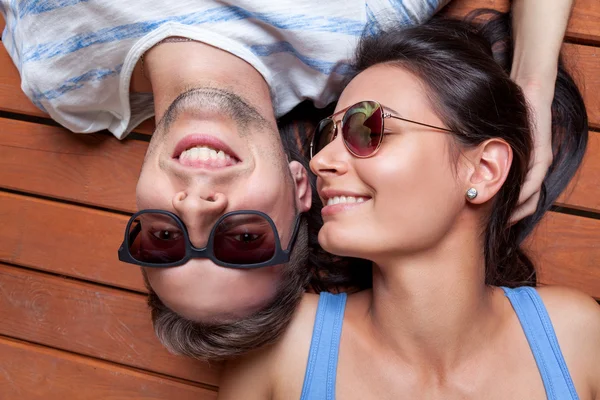 Heureux jeune couple couché sur un sol en bois — Photo