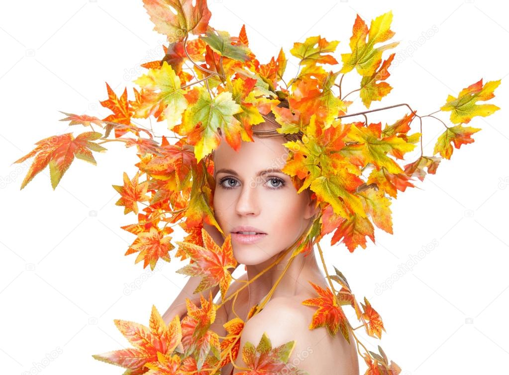 Beautiful woman wrapped in autumn leafs