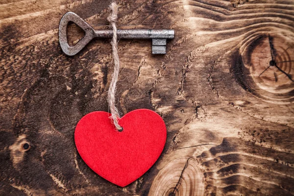 Conceito de amor. Chave velha e um coração no fundo de madeira — Fotografia de Stock