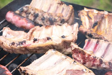 Domuz pirzolası ve sosis ızgarasını kapatıyoruz. Açık havada lezzetli pişirme süreci.