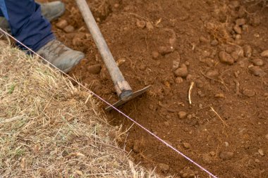 Kahverengi toprağı elle kazmak ve Dünya 'yla bağlantı kurmak.