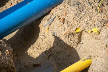 Bir inşaat alanı kazısı, mavi, sarı ve kırmızı kanal kurulumu.