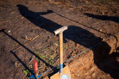 Kazı aracının yanında duran kişinin gölgesi