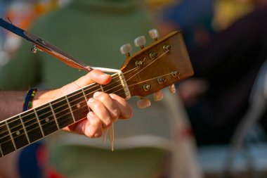 Gitar dizgileri ayarlayıcıları ve oyuncu elinin ayrıntıları