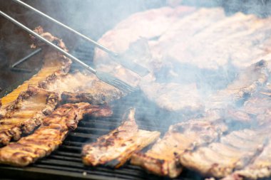 Kömür ya da gaz ızgarasındaki sulu kaburgalardan duman yükseliyor..