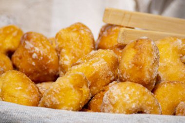 Kızarmış hamur köftelerini beyaz şeker ve ahşap maşayla kapat..