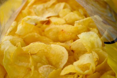 Paketlemede çıtır altın patates cipsi. Sağlıksız yemek kavramı..
