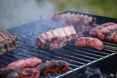 Izgarada domuz pirzolası ve sosis. Barbekü Partisi Konsepti.