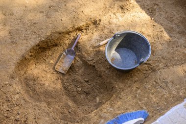 Çalışma araçlarıyla bir arkeolojik kazı çukurunun görünümünü kapat