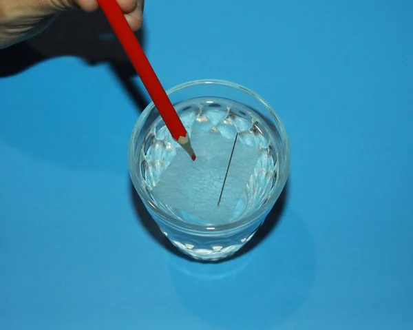 science experiment glass of water with floating needle on wada