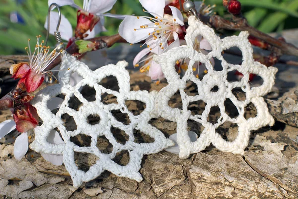 Brincos brancos de malha artesanal no fundo da natureza — Fotografia de Stock