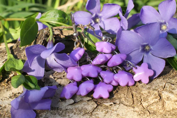 Handgjorda violett lera örhängen på naturen bakgrunden — Stockfoto