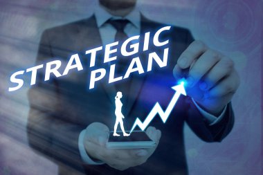 Stratejik Planı gösteren bir not yazıyorum. İş fotoğraflarında, istenilen gelecek ok sembolünün yukarı doğru kaymasının sistematik bir süreci önemli bir başarı göstermesi öngörülüyor..