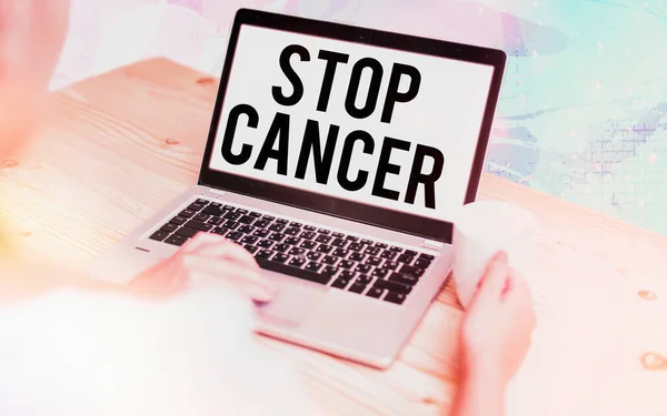 Word writing text Stop Cancer. Business concept for prevent the uncontrolled growth of abnormal cells in the body Modern gadgets with white display screen under colorful bokeh background.