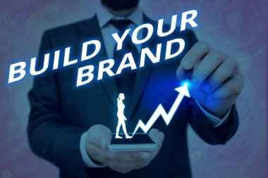 Markanızı İnşa Edin 'i gösteren bir not yazıyorum. Reklam kampanyaları kullanarak marka eşitliğini arttıran iş fotoğraflarının gösterilmesi Arrow 'un sembolünün yükselmesi önemli bir başarı gösteriyor.