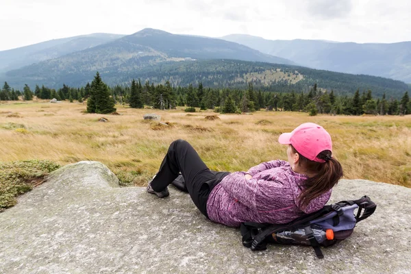 Mujer excursionista acostado en la roca en la montaña, la montaña checa Krkonose —  Fotos de Stock