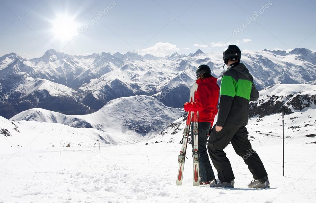 Young happy couple looking in snowy mountains