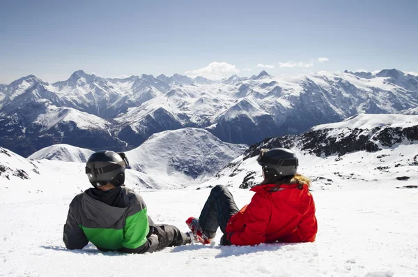 Joven pareja feliz tumbada en montañas nevadas — Foto de Stock