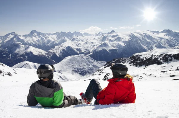 Junges glückliches Paar liegt in verschneiten Bergen — Stockfoto