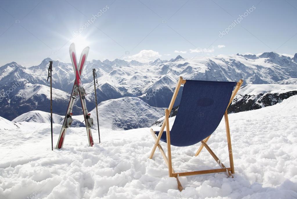 Cross ski and Empty sun-lounger at mountains in winter
