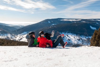 karlı dağlar içinde yatan genç mutlu çift çek