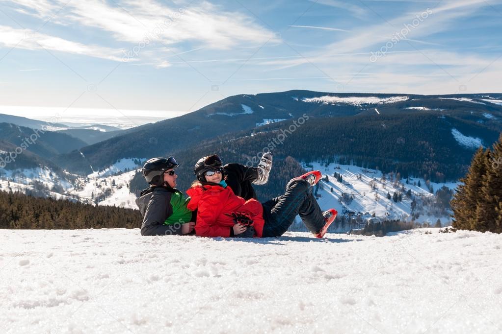Young happy couple lying in snowy mountains, czech