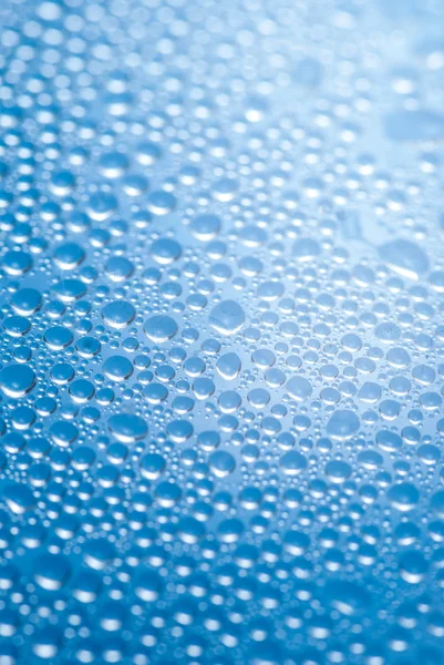 Close-up van water druppels op de blauwe achtergrond — Stockfoto
