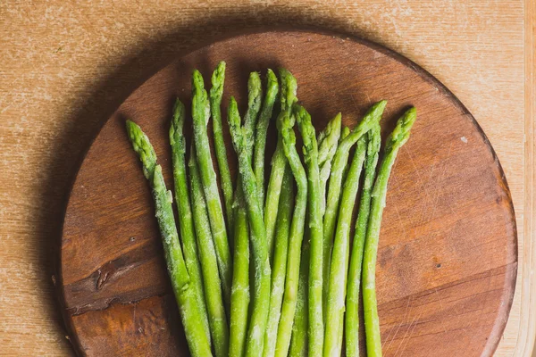 Bevroren stokken van asperges op rustieke houten achtergrond. horizontale weergave. — Stockfoto