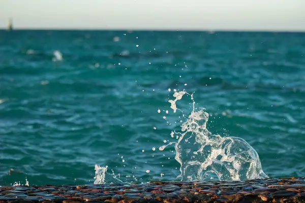 美しい透明な青緑色の海海水面の波紋と明るいスプラッシュ海の背景画像の水平方向の写真のクローズ アップ — ストック写真