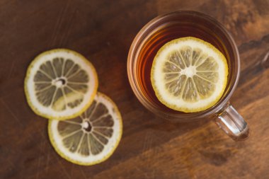 Siyah çay Kupası ve ahşap tahta masada limonlu Üstten Görünüm