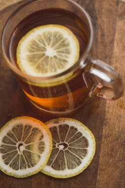 Siyah çay Kupası ve ahşap tahta masada limonlu Üstten Görünüm