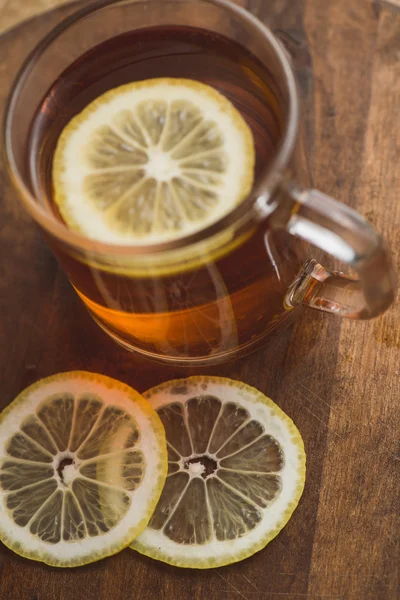 Vue du dessus du thé noir au citron dans une tasse et sur une table à planches en bois — Photo