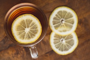 Siyah çay Kupası ve ahşap tahta masada limonlu Üstten Görünüm
