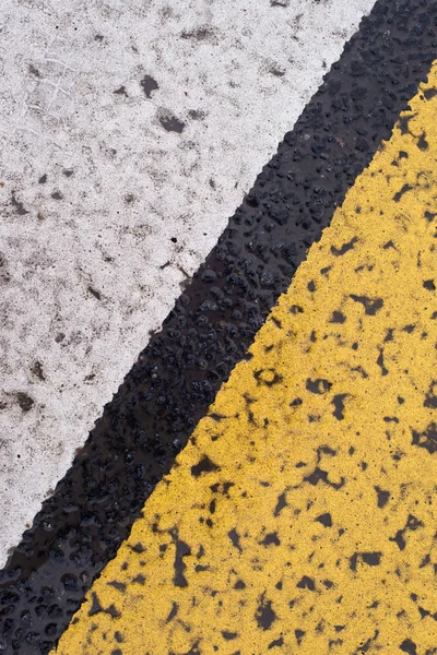 Asphalt Highway Textur mit rissigen weißen und gelben Streifen — Stockfoto