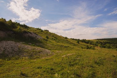 ormanlar, bulutlar ve yeşil tepe ile manzara