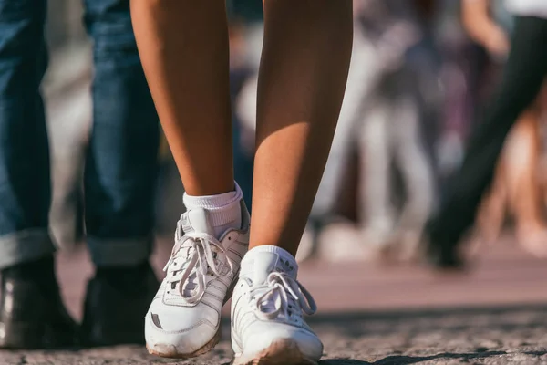 MOSCOU, RUSSIE-09 MAI 2015 : les gens dansent à l'extérieur dans le parc sur le remblai de Pushkinskaya par une journée ensoleillée. Baskets adidas blanches sur les pieds des femmes au premier plan — Photo