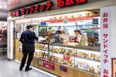 Bir adam Bento Bento Tokyo İstasyonu, Japonya mağazasında satın alma