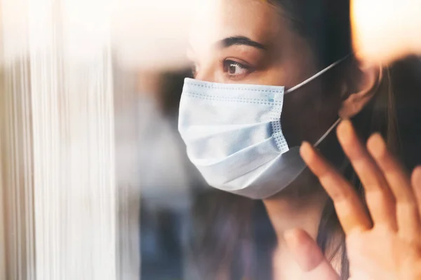 Frau Mit Maske Schaut Aus Dem Fenster — Stockfoto